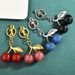 Bag Charm Factory Direct Sales Hot Selling Multi Color Cherry Lock Ring Fashion Personality Bag Fruit Pendant Accessories Jewelry Wholesale_viptrois.com